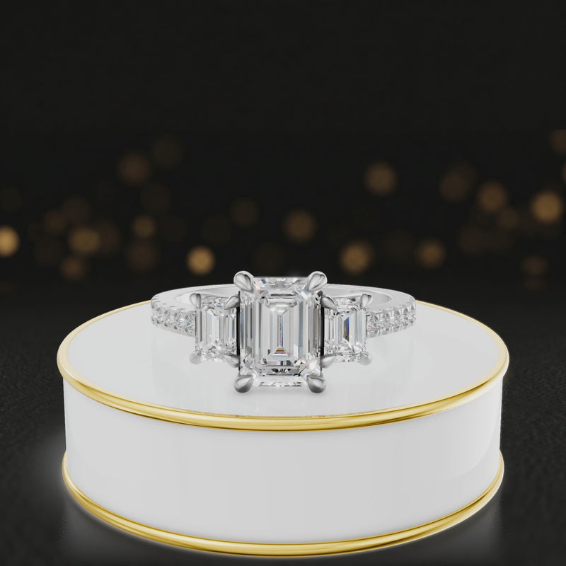 360-degree rotating view of an emerald cut three-stone lab-grown diamond engagement ring in 18kt white gold with diamond shoulders